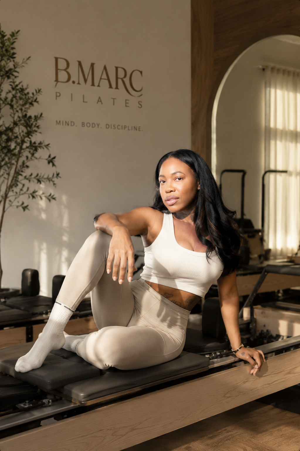 Founder on a reformer in the B.MARC studio with warm neutral lighting